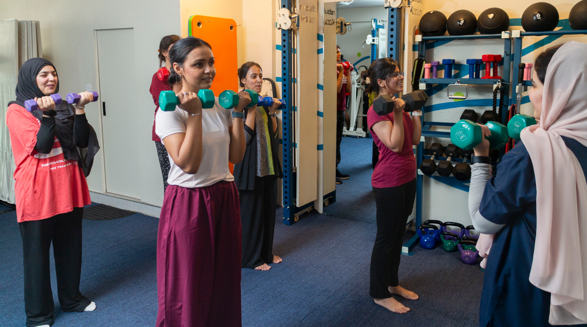 Women training together with dumbbells at Karavan Studios