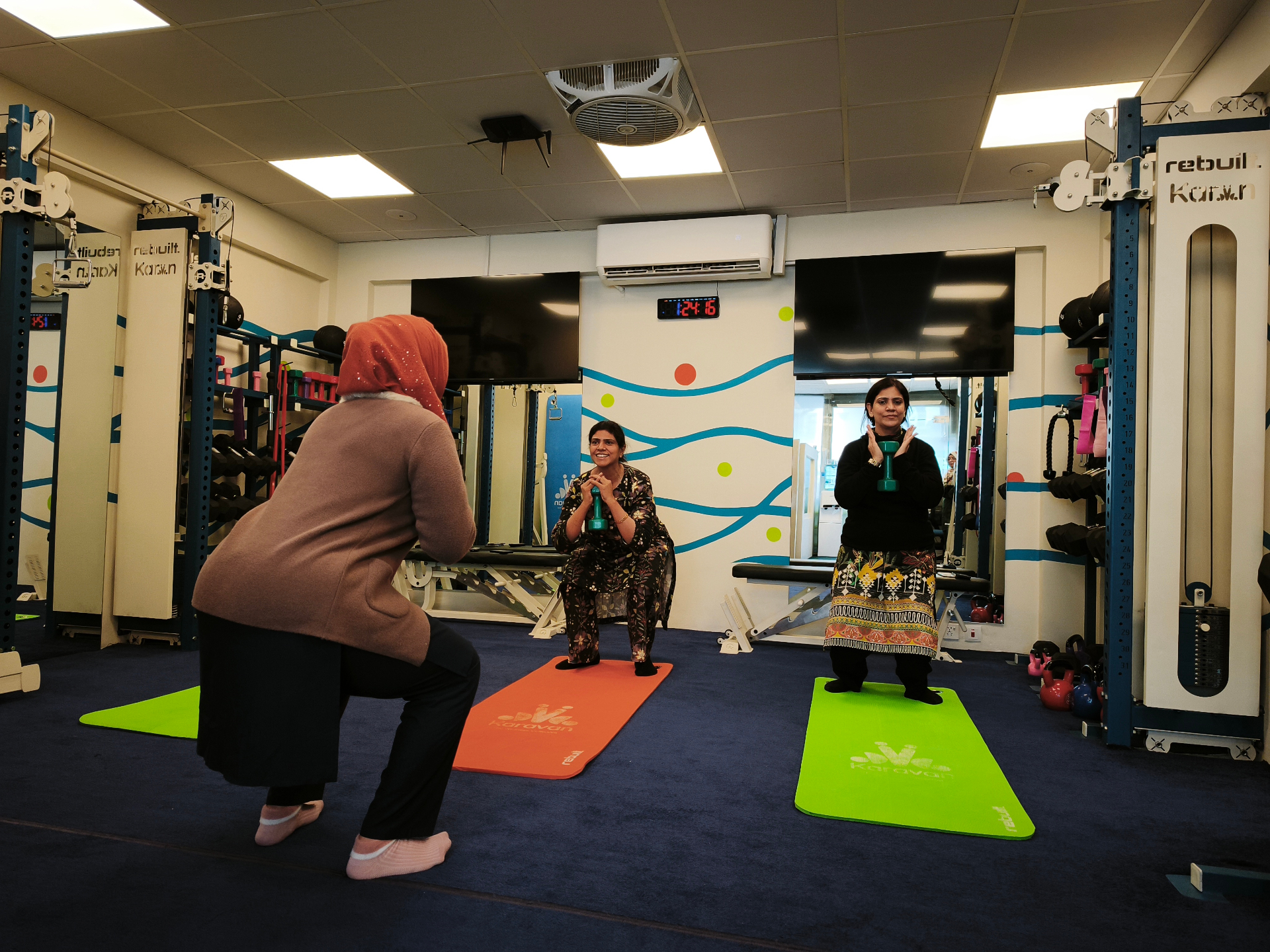 Group class squatting together in the Karavan I-8 studio