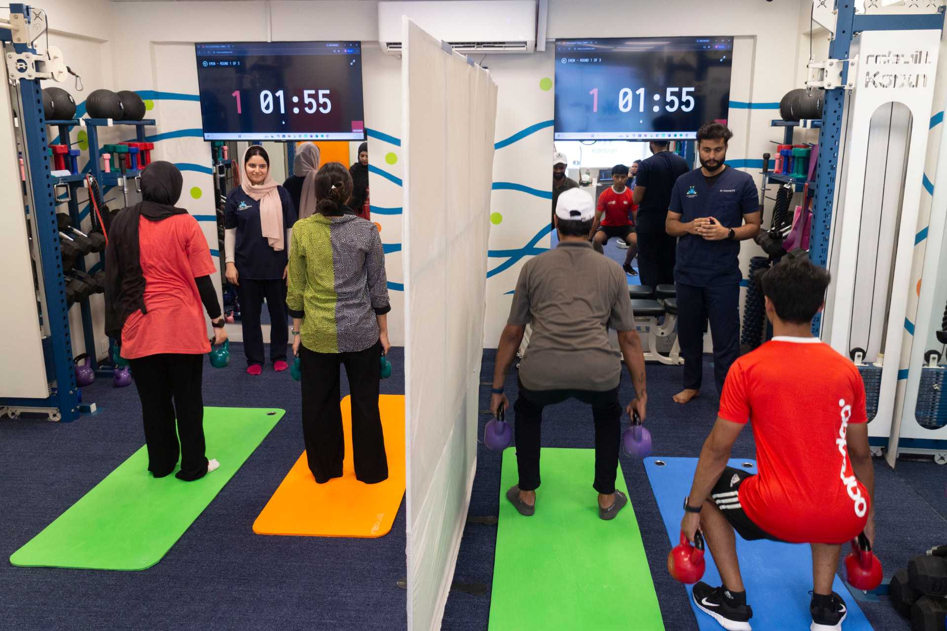 Members completing kettlebell squats in a coached studio session